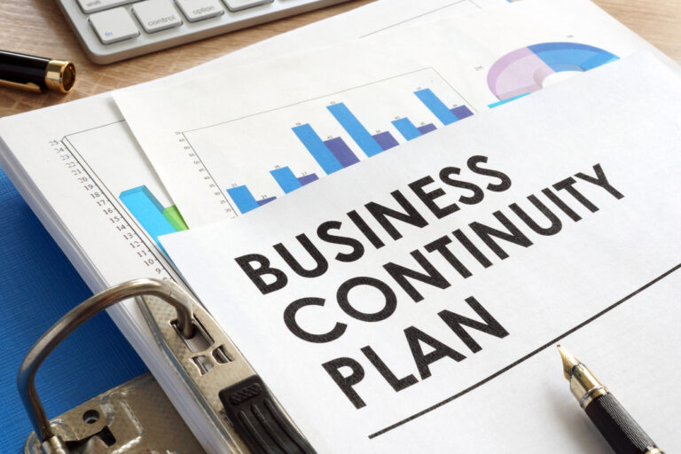 Business continuity plan document on a desk with charts and a pen